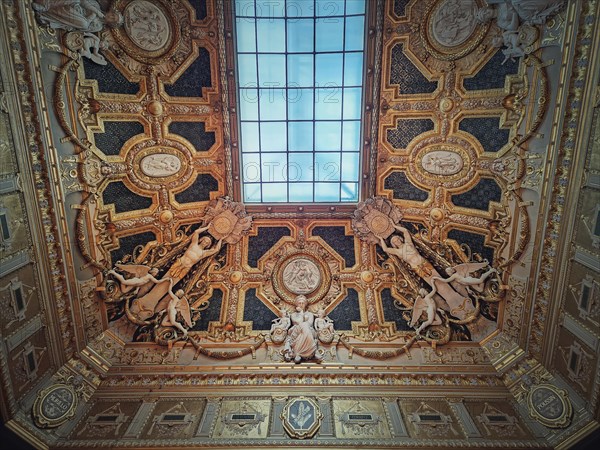 Golden ceiling with architectural details of the Salon Carre inside Louvre museum