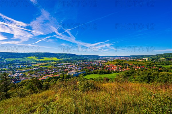 View over the city of Jena from the Galgenberg with the Kernberge in the background under blue sky and veil clouds
