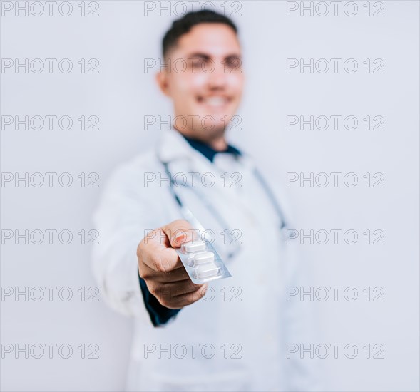 Young doctor offering a pill isolated. Pharmacist recommending a pill isolated