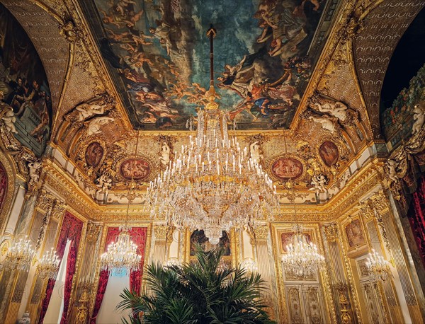 Beautiful decorated Napoleon apartments at Louvre palace. Royal family rooms with cardinal red curtains