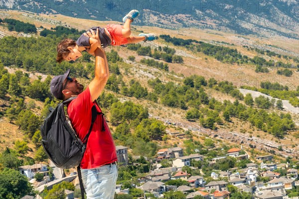 Portrait of a father with his son having fun in the Ottoman Castle Fortress of Gjirokaster or Gjirokastra. Albanian