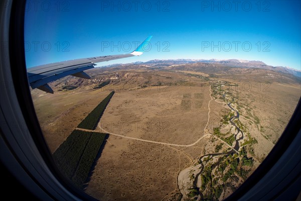 View from the plane of the Patagonian steppe with a river and a pine plantation near Bariloche