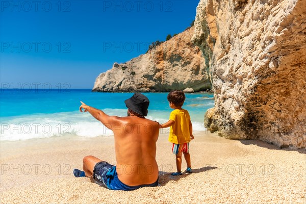 A father and child having fun on Porto Katsiki beach in summer vacation Lefkada island