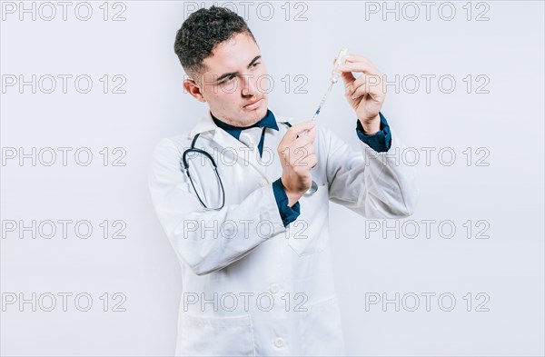 Doctor drawing antidote from a vial. Concept of doctor with disease antidote. Handsome doctor drawing medicine from a vial with copy space