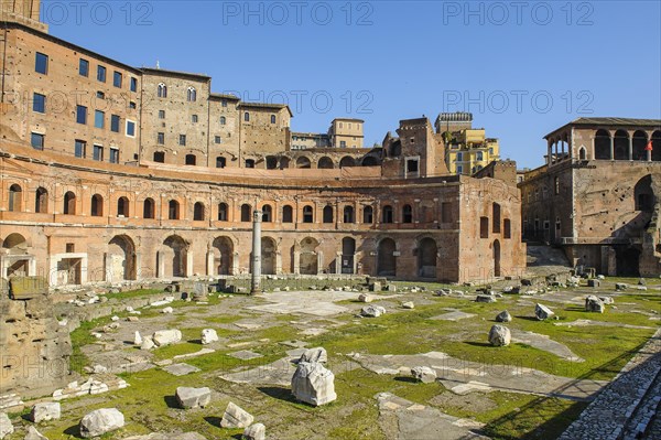 View of historic Forum of Traian Foro Traiano from antiquity with building in semicircle at rear with colonnade in foreground forecourt open space with column fragments remains of marble columns