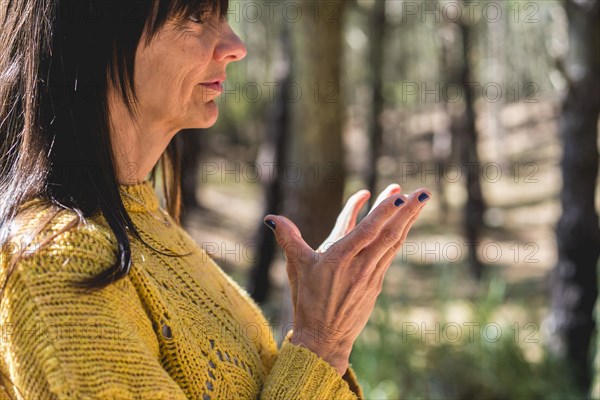 Side view of Padma mudra executed by a woman over nature background