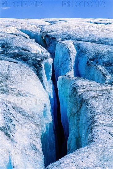 Melting glacier with a deep crevasse a sunny summer day