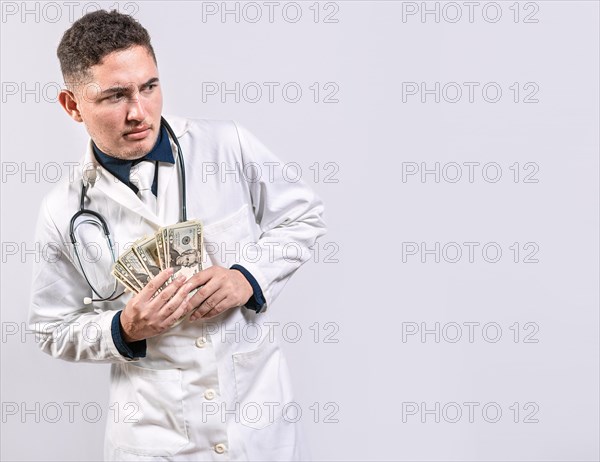 Dishonest doctor holding bribe money on white background. Corrupt doctor holding bribed money isolated. Corrupted doctor concept