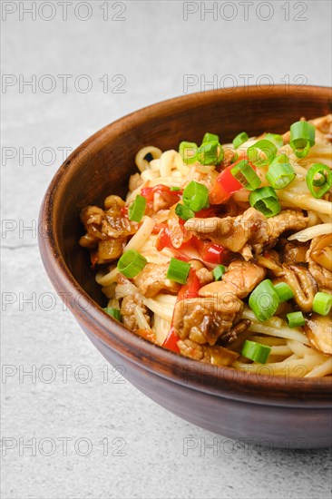 Closeup view of udon noodle with pork and mushrooms in sweet chilli sauce