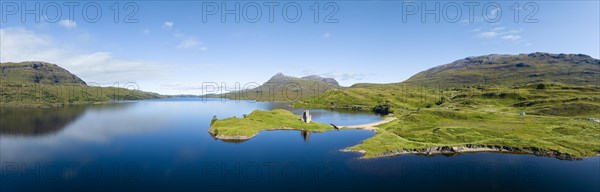 Aerial panorama of the freshwater loch Loch Assynt with the ruins of Ardvreck Castle on a peninsula