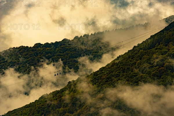 Mountain Cable Car with Clouds and Sunlight in Miglieglia