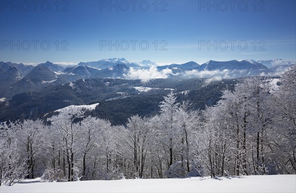 Winter landscape covered in deep snow at the summit of the Zwoelferhorn with a view of the Osterhorn group