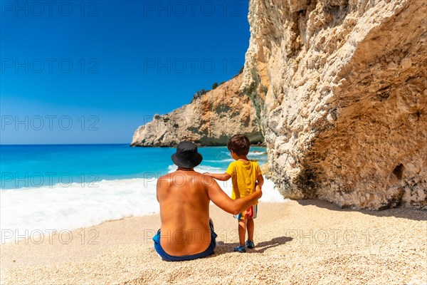 A father and child having fun on Porto Katsiki beach in summer vacation Lefkada island