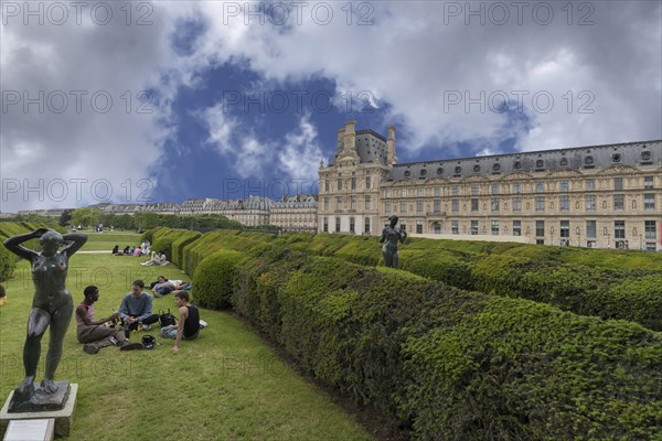 Young people on the green spaces in front of the Louvre