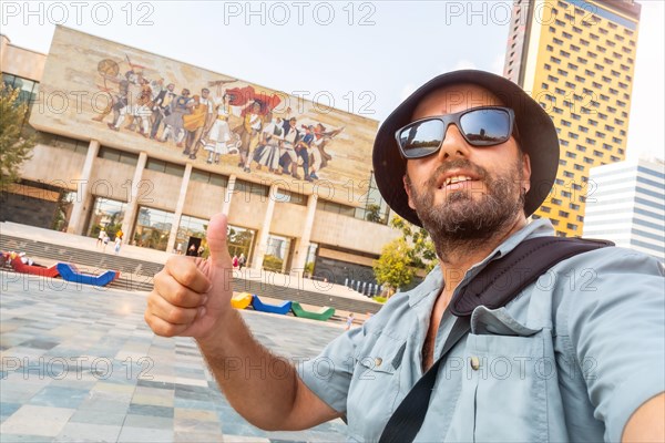 A male tourist at the entrance to the National Historical Museum in Skanderbeg Square in Tirana. Albania