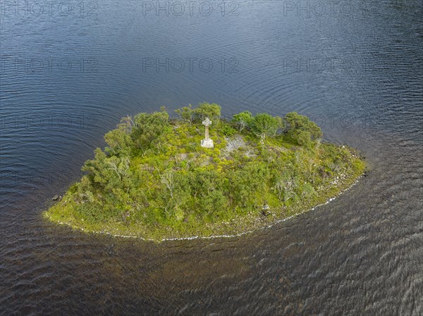 Aerial view of a small island with a Celtic stone cross in the freshwater loch of Loch Stack in the Northern Highlands