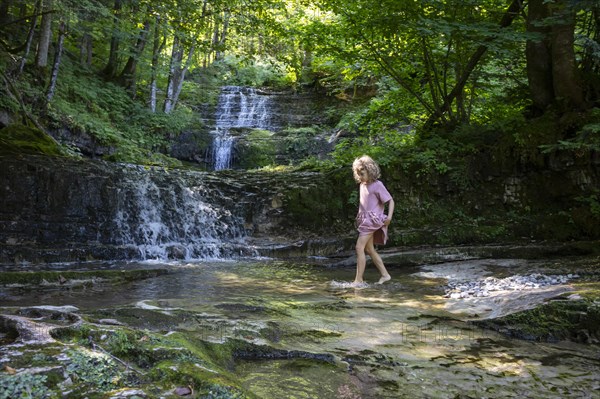 Girl playing on the bank of the Taugl at the Wald Wasser Zauber Weg near Hintersee