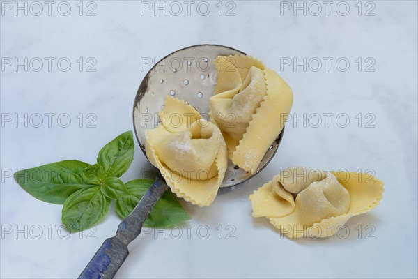 Freshly prepared tortelloni in a sieve ladle