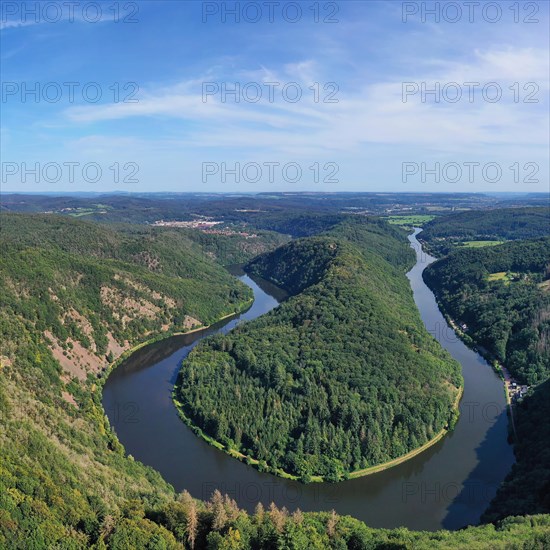 Aerial view of the Saar Loop. The Saar winds through the valley and is surrounded by green forests. Orscholz