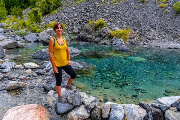 A young woman in the turquoise water reservoir in the valley of Theth national park