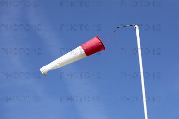 White-red windsock against blue sky