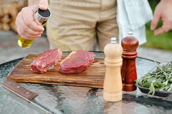 Sprinkling club beef steak with olive oil