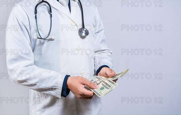 Medical corruption concept. Corrupt doctor counting money isolated