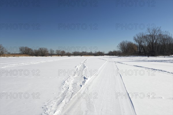 Vehicle tracks on snow covered frozen river