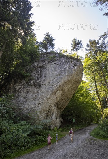 Hikers standing in front of the natural monument Satzstein near Hintersee