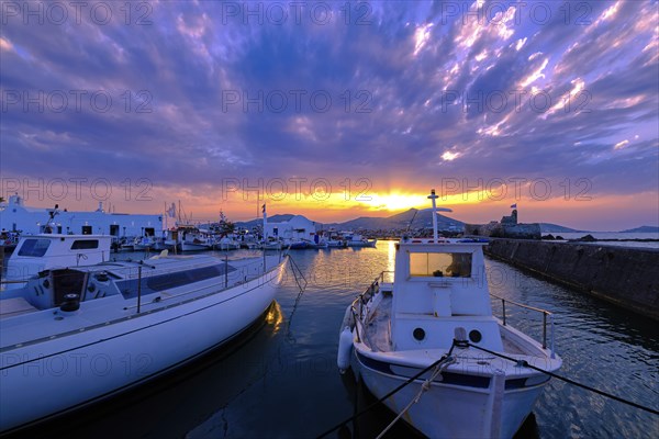 Colorful sunset over quiet Greek fishing village and its harbour