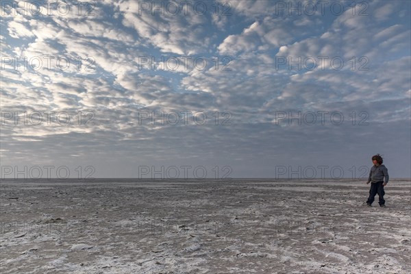 Boy running through salt desert