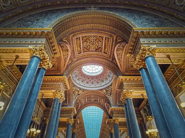 Ceiling architectural details with the glass dome and golden ornaments inside the Versailles palace hall