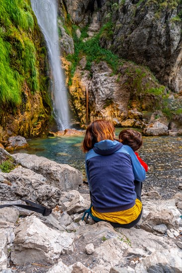 Woman with her child at Grunas waterfall in Theth national park