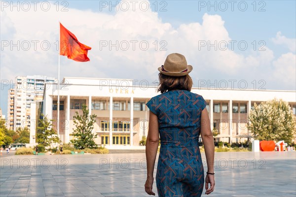 A tourist visiting the Palace of Culture or Opera in Skanderbeg Square in Tirana. Albania