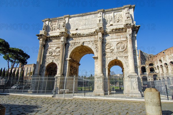 Perspective view from close up of Arch of Constantine Triumphal Arch of Emperor Constantine without tourists deserted in the background right Colosseum