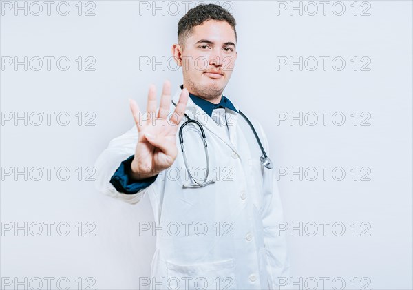 Handsome doctor counting number 4 on isolated background. Doctor counting number four isolated