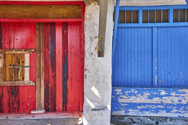 Colorful blue and red boat garage doors in Klima fishermen village