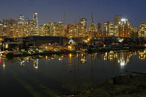 Illuminated skyscrapers and sailboats in the last evening light