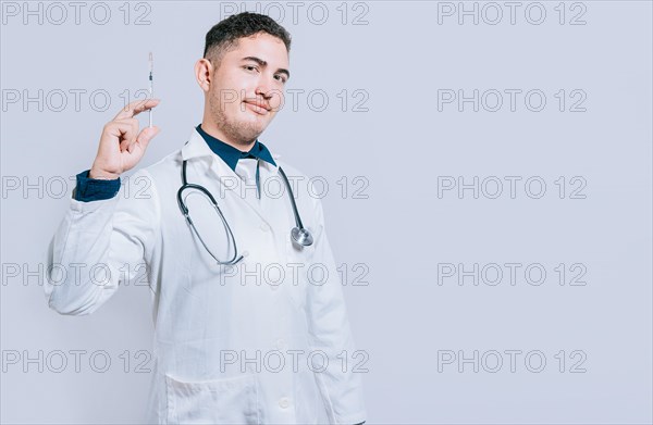 Friendly doctor holding a syringe isolated. Smiling doctor showing a syringe on isolated background. Doctor and vaccine concept