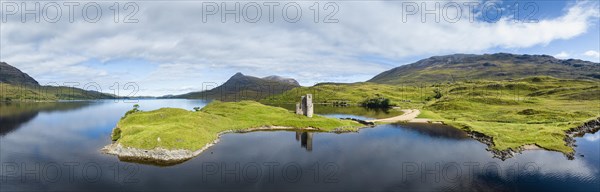 Aerial panorama of the freshwater loch Loch Assynt with the ruins of Ardvreck Castle on a peninsula