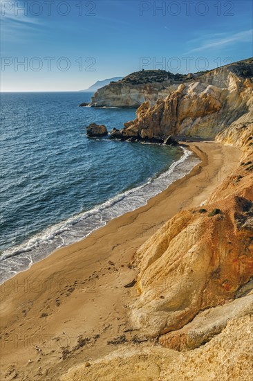 Beautiful sunset view of secluded and remote beach on sunny evening. High yellow cliffs