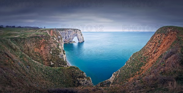 Sightseeing panoramic view to the Porte d'Aval natural arch cliff washed by Atlantic ocean waters at Etretat