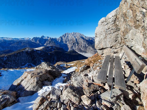 Wooden bench as a resting place at the Rossfeldern above the Priesbergalm in the Berchtesgaden National Park with a view of the Watzmann and the Steinernes Meer