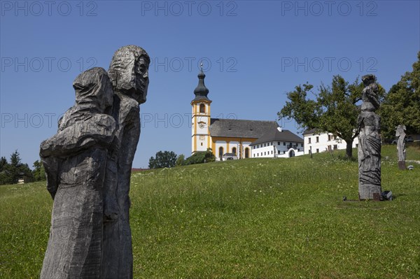 Wooden sculptures at the Stations of the Cross on Kirchberg with parish church