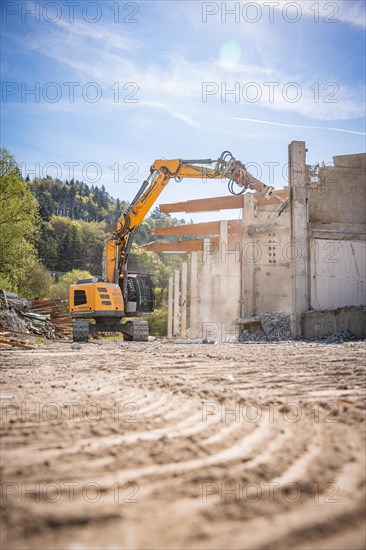 Yellow Liebherr crawler excavator recycling on demolition site