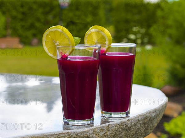 Freshly squeezed juice of beetroot with apple and lemon in a juice glass