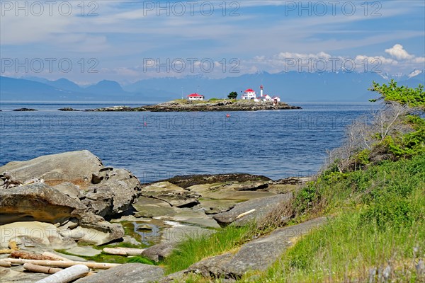 Beach and rocky bay with lighthouse