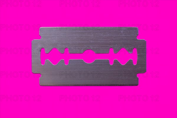 Razor blade against magenta background