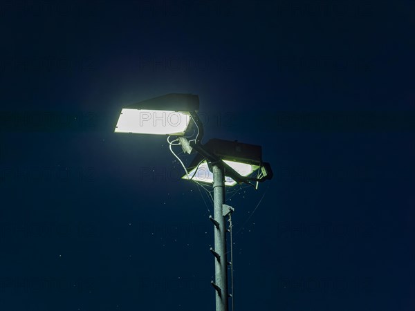 Spotlights on the football pitch in the night sky
