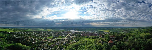 Aerial view of Koenigsberg in Bavaria. The city is surrounded by hills and forests. The sky is cloudy and dark